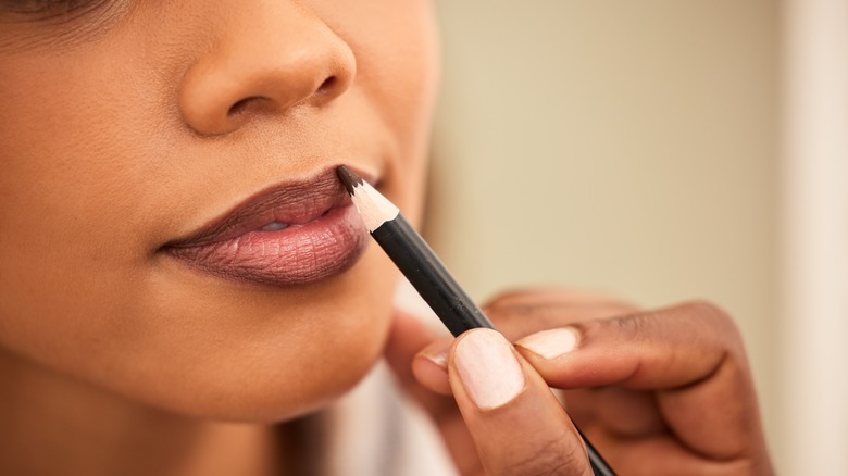 Woman applying dark lipliner