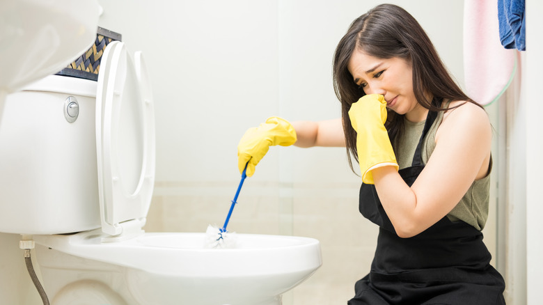 woman cleaning toilet