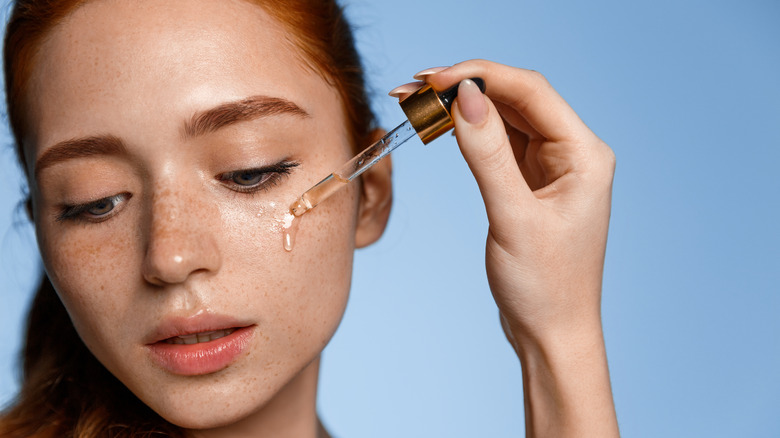Woman applying a serum to her face