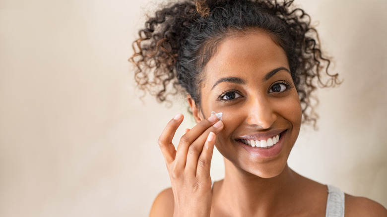 Woman applying moisturizer