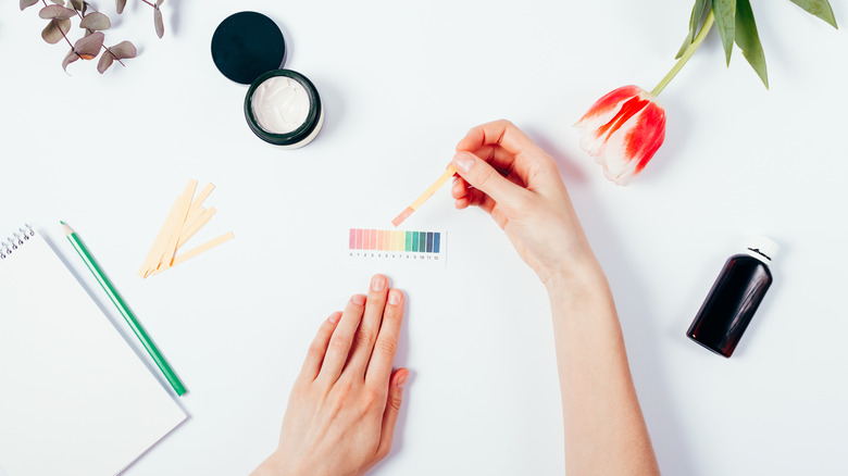 Woman testing the pH of beauty products