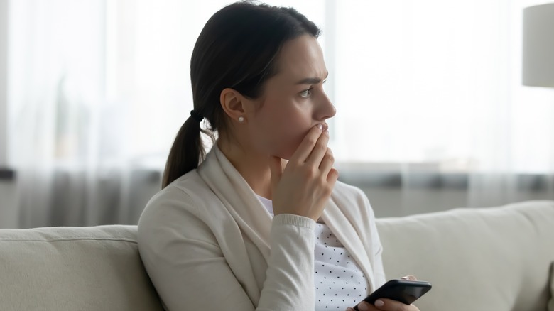 woman looking distressed sitting on couch