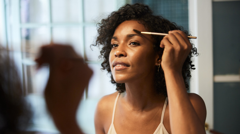 A woman brushing her eyeborws