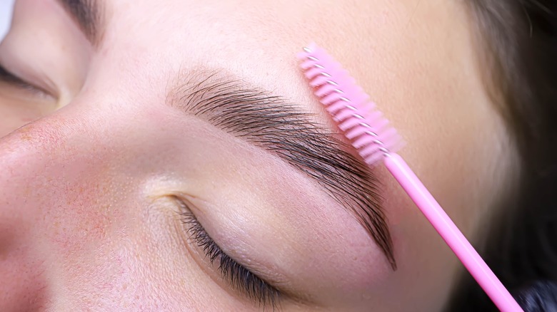 A woman getting her eyebrows laminated