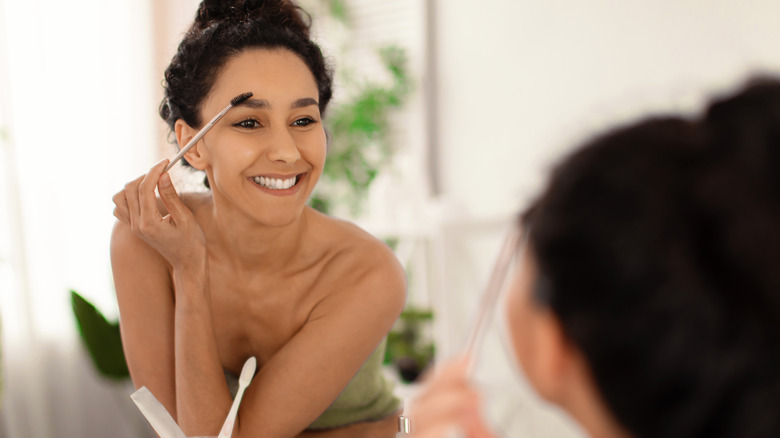 A woman brushing her eyebrows