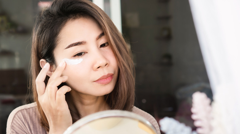 Woman applying under eye cream