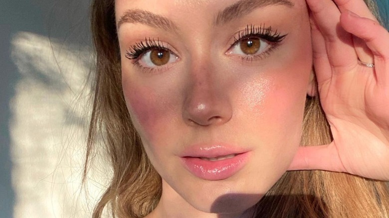 Woman with cream blush on her cheeks