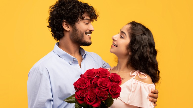 Man giving his girlfriend red roses