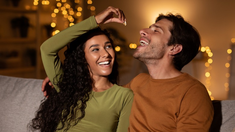 Couple eating popcorn on the couch 