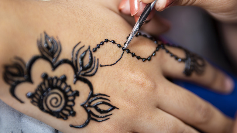 Black henna being applied