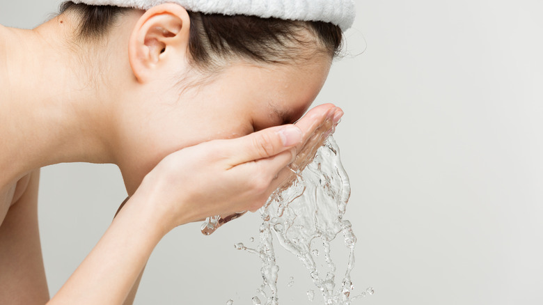Woman splashing face with water