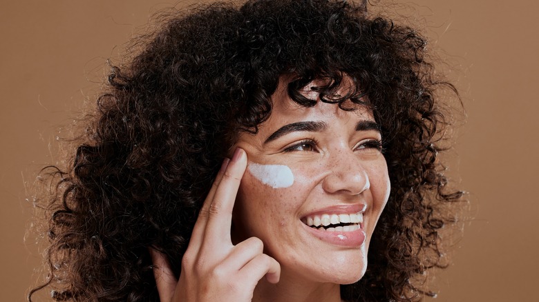 Woman applying moisturizer