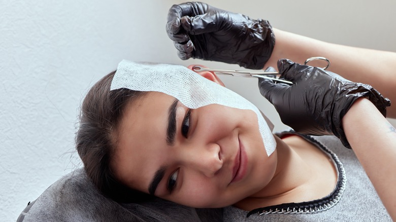 woman getting her ear pierced