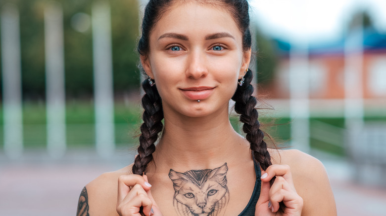 Model in sports bra with chest tattoo