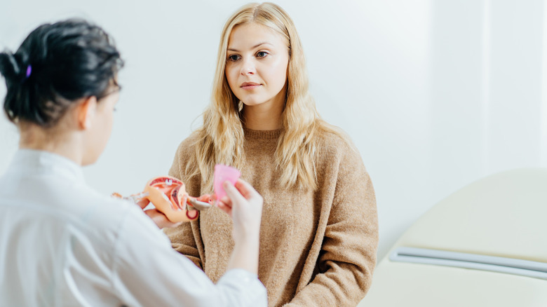 doctor showing woman menstrual cup