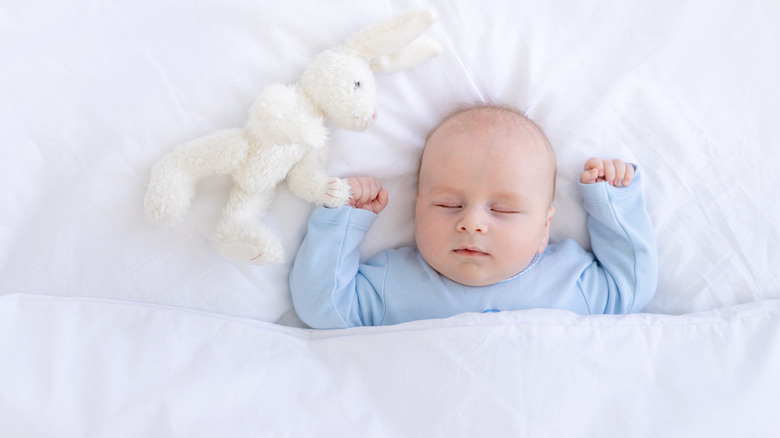 a baby sleeping under a blanket