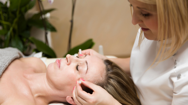 Woman getting facial cupping done at a salon