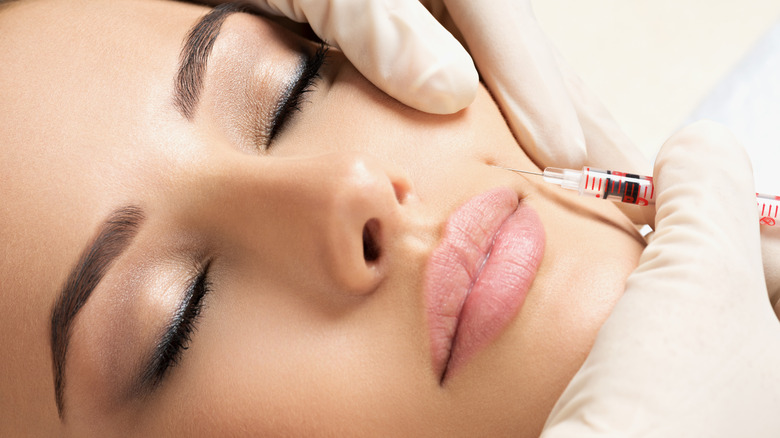 Woman being injected in her cheek