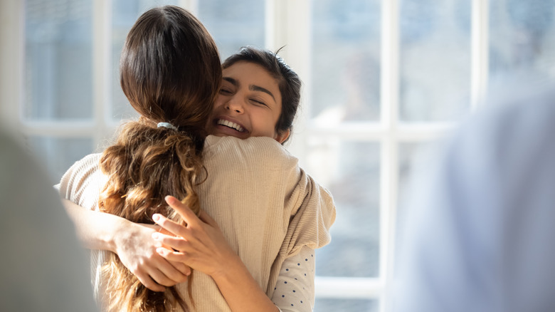 Encouraging woman hugging friend