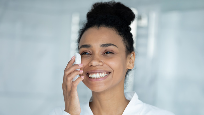woman scrubbing bar on face