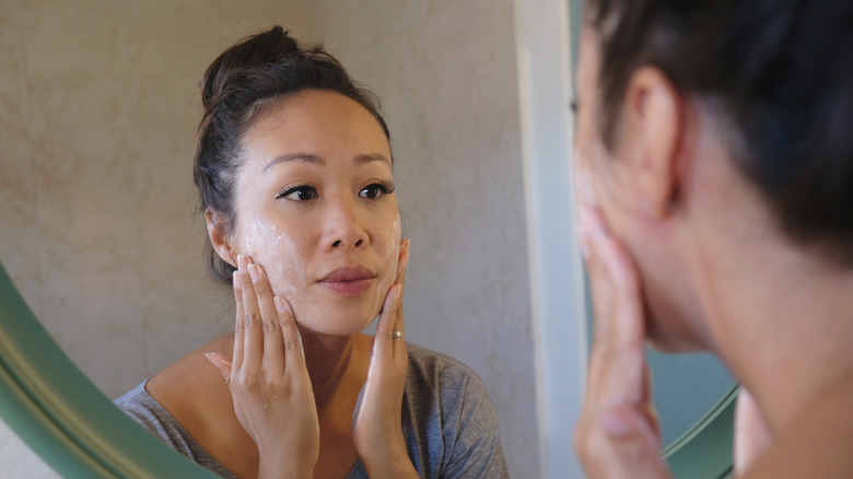 woman exfoliating face