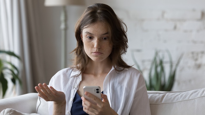 upset woman holding phone