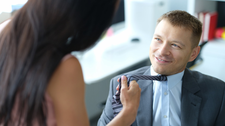 woman pulling man's tie