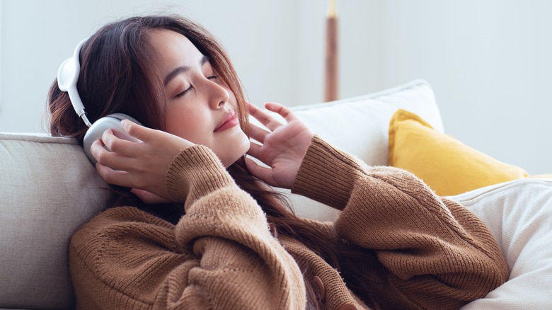 Smiling Asian girl relaxing with headphones