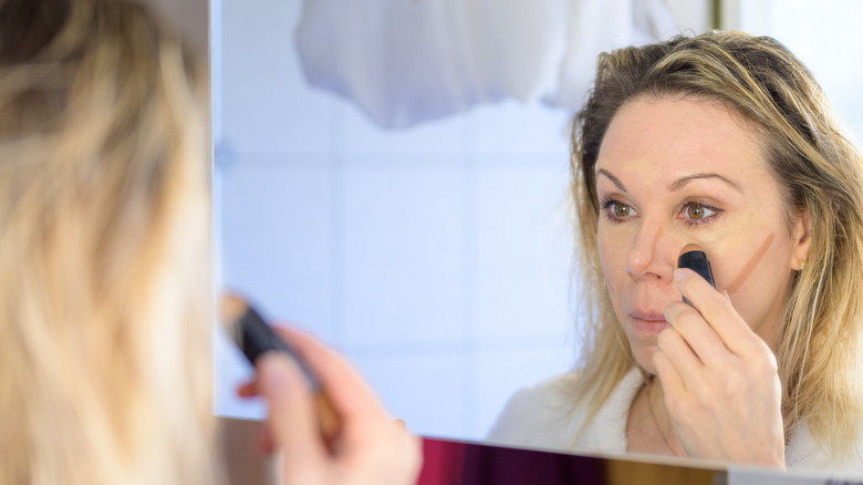 Woman applying concealer