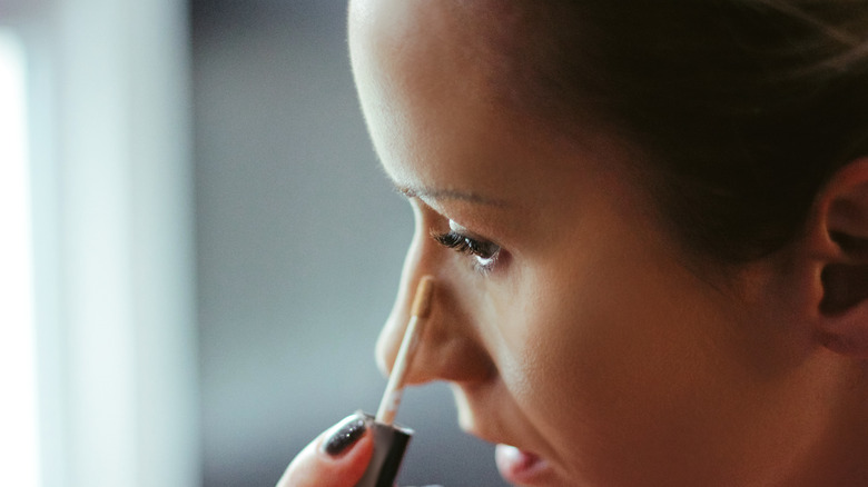 Woman applying concealer