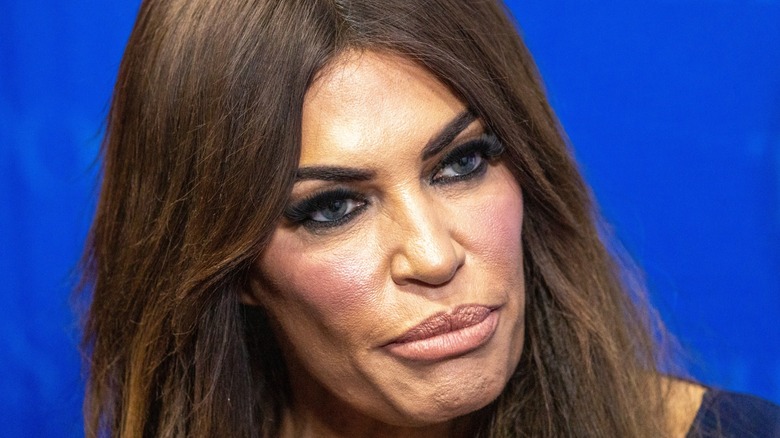 Close-up of Kimberly Guilfoyle looking stern against a blue backdrop.