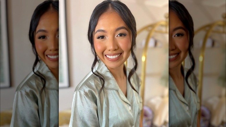 Woman poses with loosely curled hair tendrils 