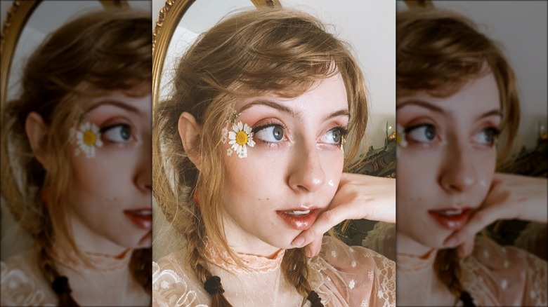 woman with daisy on face
