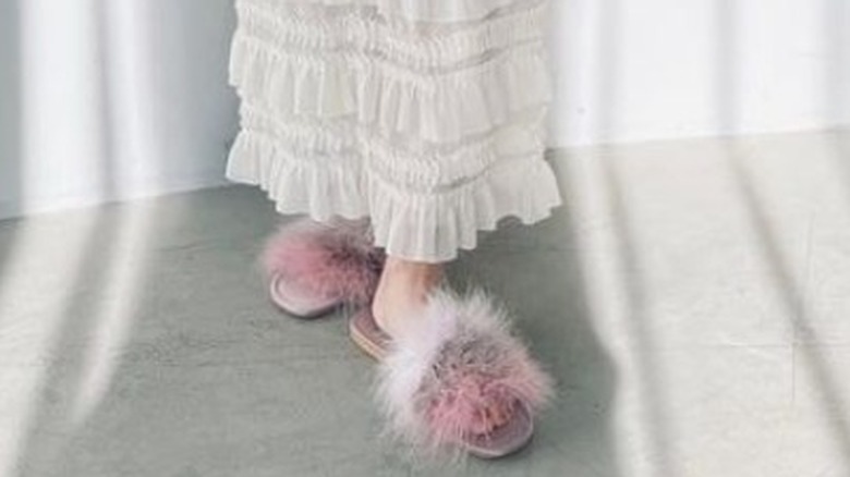 Woman poses in long skirt and fur slides 