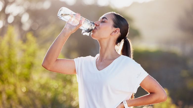 Woman drinking water outdoors