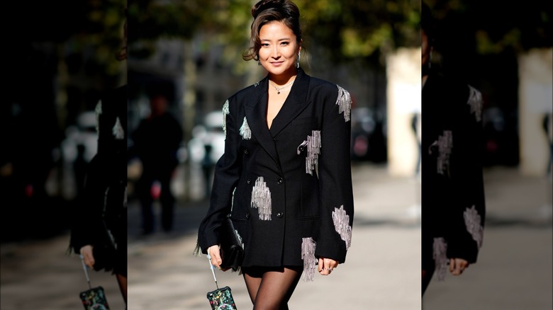 Ashley Park wearing blazer with fringe accents