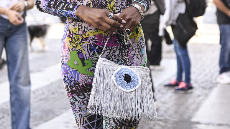 Woman carrying fringe handbag