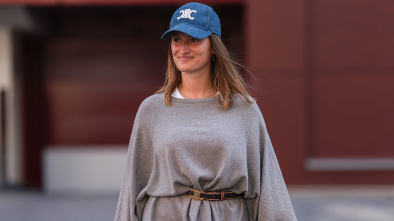 A woman wearing baggy gray clothing