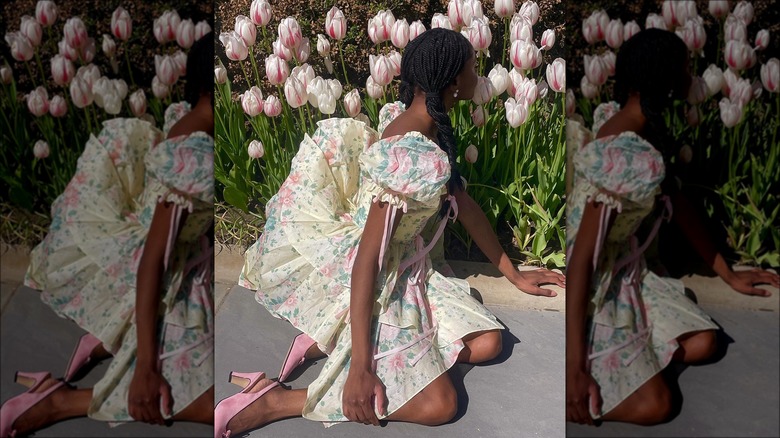 Woman wearing floral dress posing with flowers