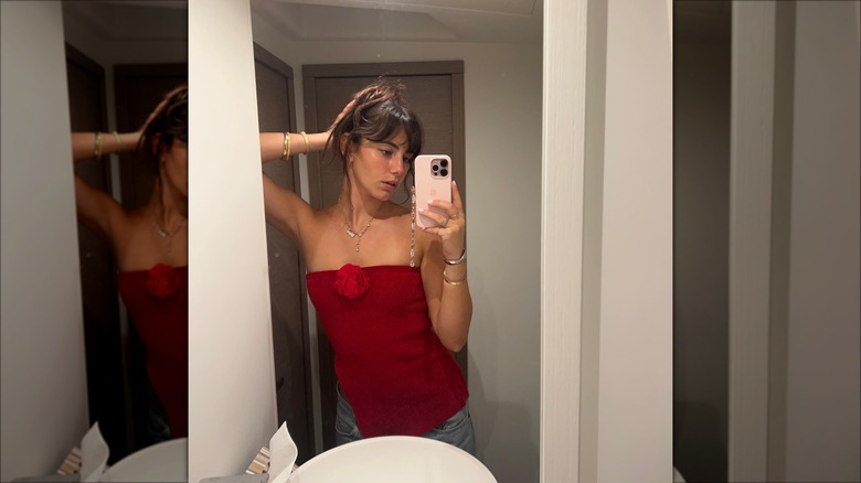 Woman wearing red tube top with flower appliqué