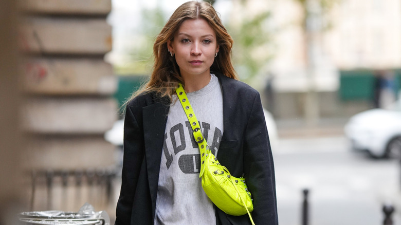 A woman waering a gray sweater with large text on it