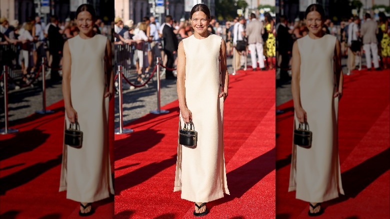 Person in white column dress and black flip-flops