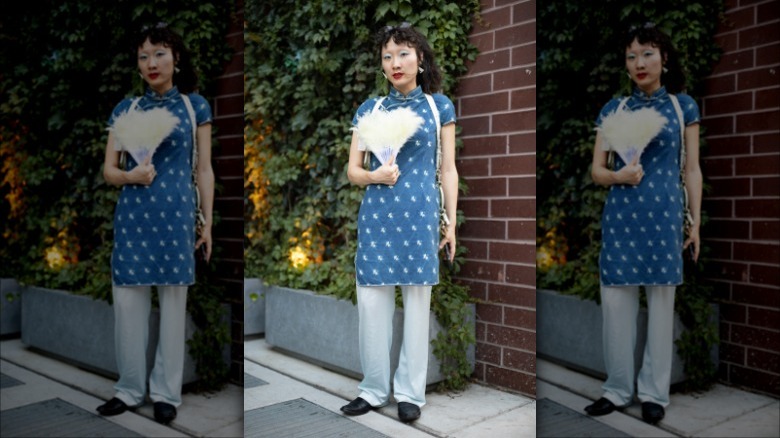 woman with a white feather folding fan
