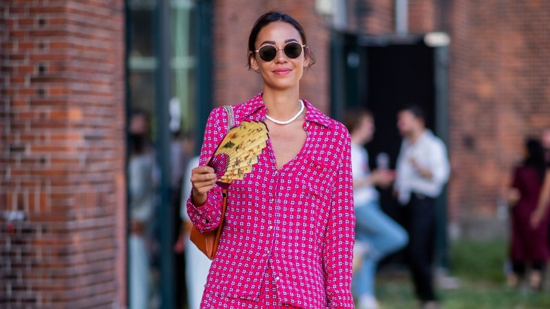 woman with a yellow printed folding fan