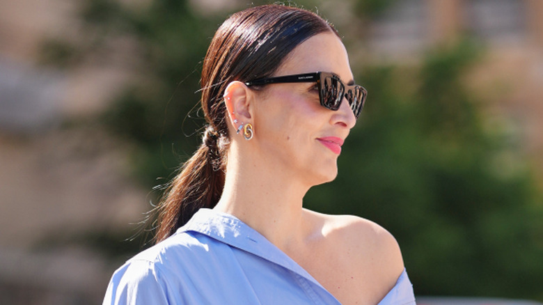 A woman with her hair in a low brunette ponytail