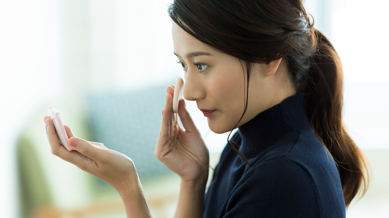 woman applying foundation