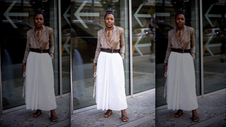 woman wearing a plaid blazer and white full skirt