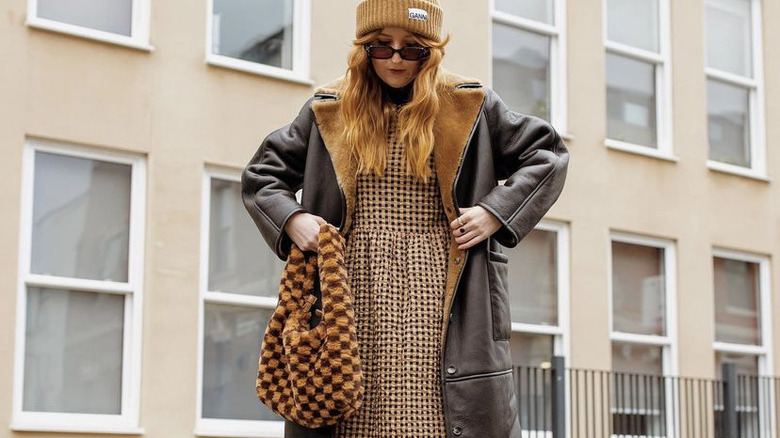 woman wearing beanie, coat, fuzzy bag