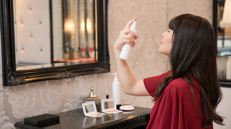 woman spraying on toner at her vanity