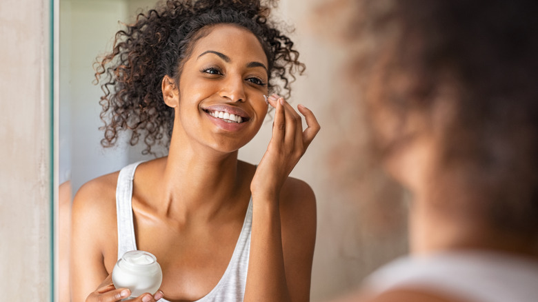 woman applying moisturizer